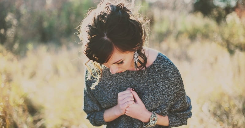 sad young woman praying, comforting bible verses for grief and loss