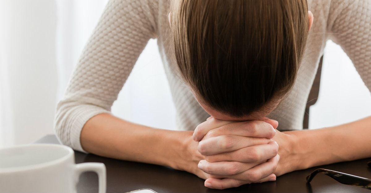 40724 prayer woman womanwithheadondesk desk headdown.1200w.tn