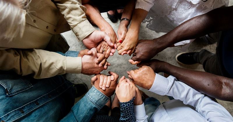 People holding hands in a prayer circle