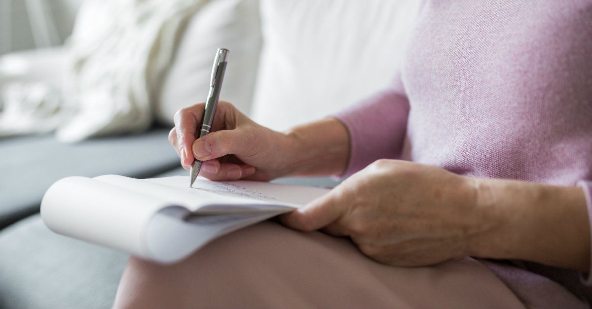 woman writing on a notepad