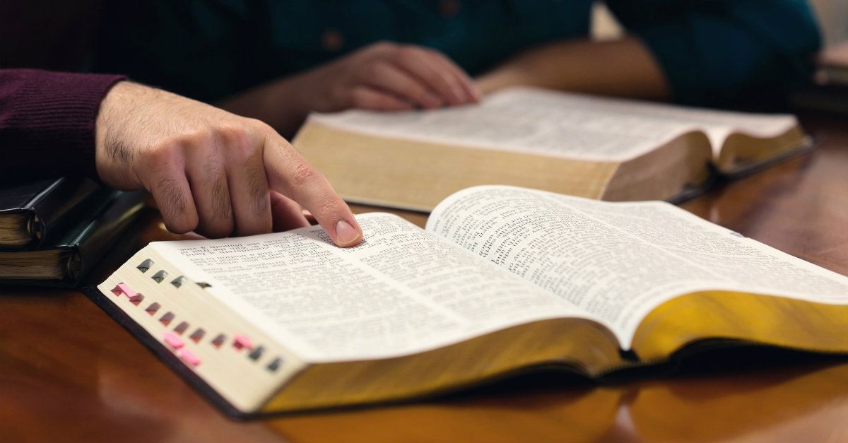 people studying the bible, finger pointing at scripture