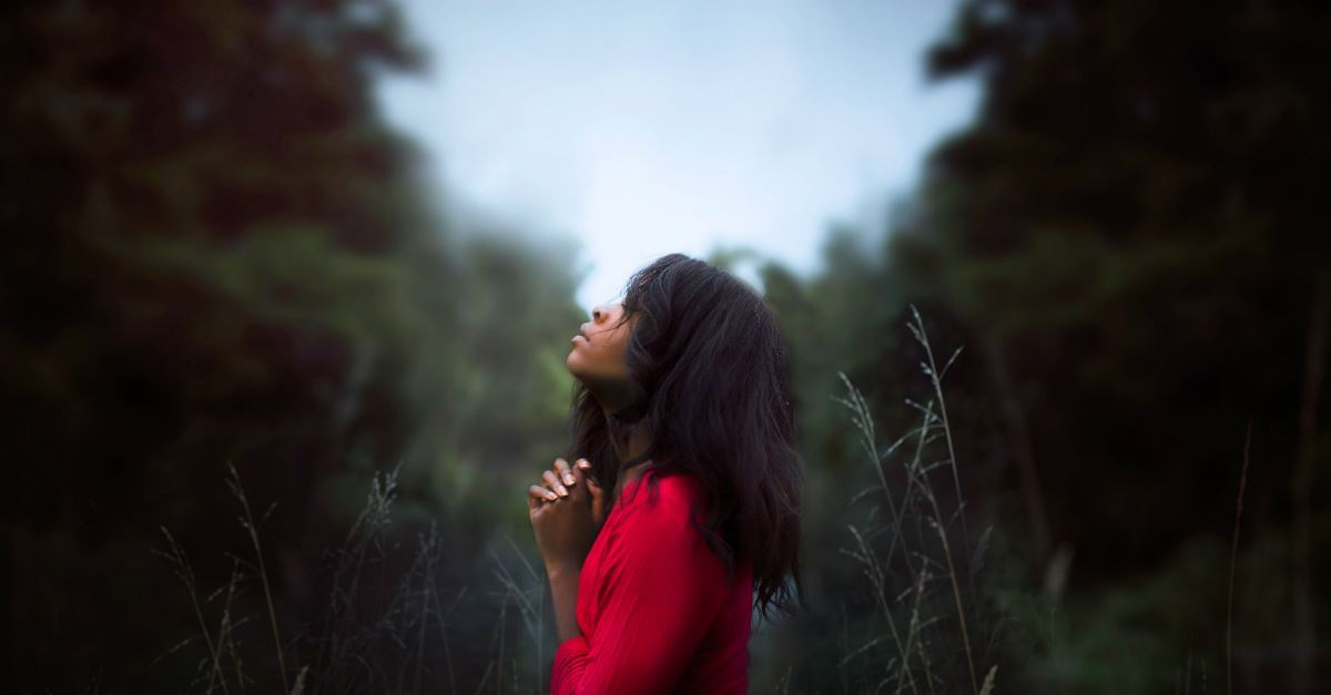 woman in a field praying