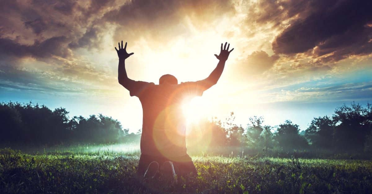 man kneeling and praying at sunrise, things that stop us from praying for revival