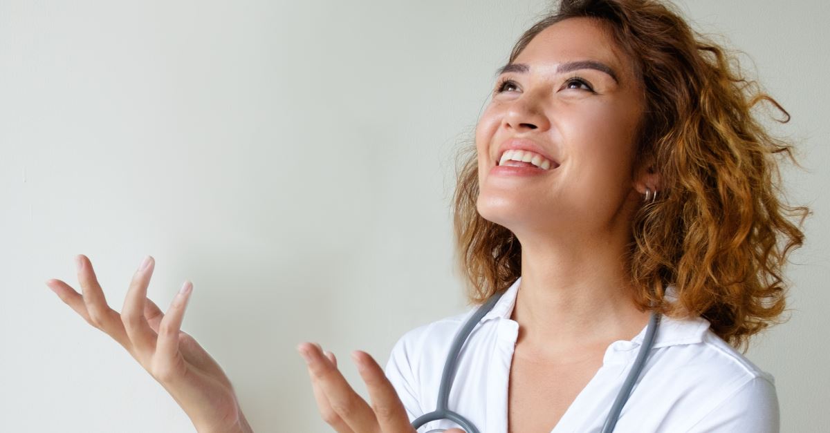 woman looking up an smiling, hands open as if talking happily and casually with God