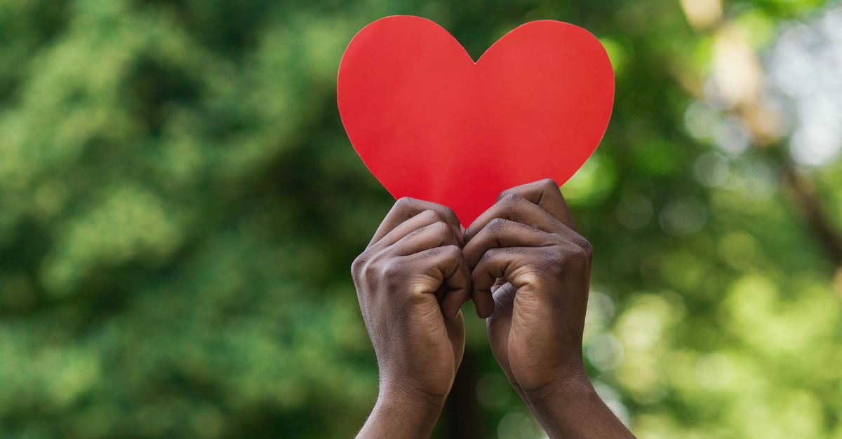 tween kids' hands holding up red paper heart