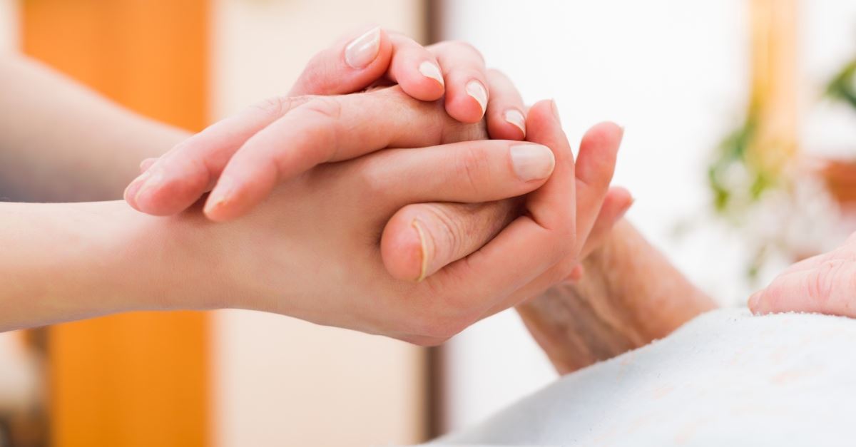 woman holding the hand of a sick person in the hospital