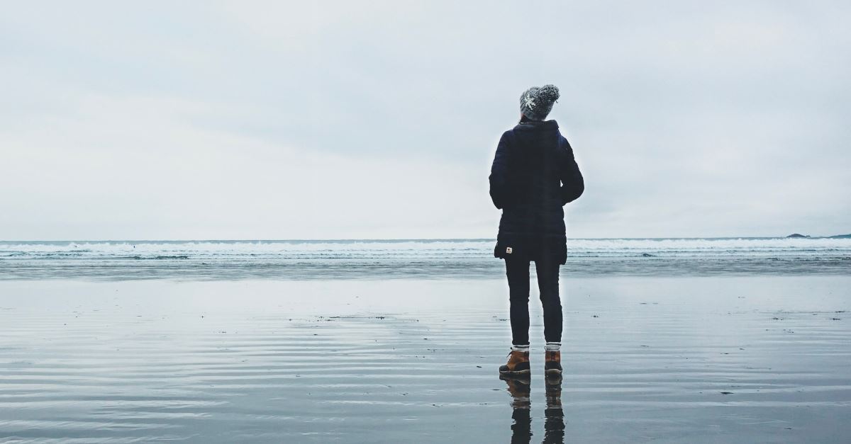 back of woman winter clothes standing in front of ocean, how to be still in restless culture