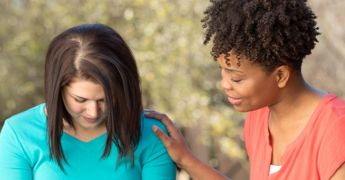 women praying for each other touching arm