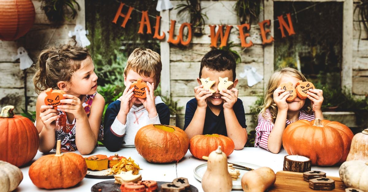 kids holding cookies carving pumpkins halloween