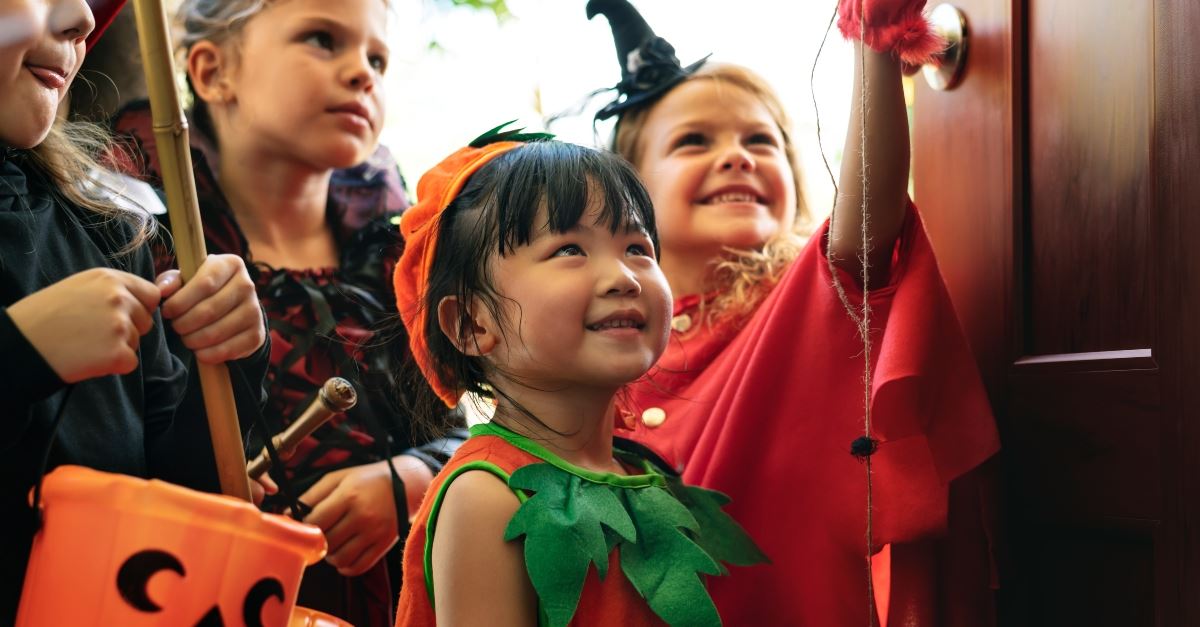 kids at door trick or treating in costumes at halloween