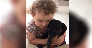 Little Girl Snuggles With Puppy