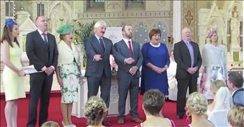 Irish wedding ceremony had a special twist that no one saw coming. A group of their friends wanted to give Bernie and Cian a ceremony to remember so they came together to plan a big surprise. 

They decided to perform a flash mob and the bride and groom had no clue it was going to happen. Just look at their faces when members of the crowd stand up and start to sing Abba's classic song 'The Way Old Friends Do.' It's obvious that they were overcome with joy at this talented performance. And then they followed up with the Liverpool anthem 'You'll Never Walk Alone' especially for Cian. 

The groom is a huge Liverpool fan so they wanted to add in this song for him. How amazing and unforgettable was this?