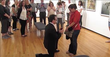 I thought I had seen every possible flash mob proposal out there, but then this one came along and I was completely floored. Jennifer thought that her and her boyfriend, Sean, were just going to dinner but little did she know there was something much bigger planned. The couple was going to stop by the Museum Of Contemporary Photography before dinner. 

For his first surprise, Sean had one of their favorite photos framed and placed in the museum. As Jennifer is looking at the photos, Sean pretends that he left his cellphone in the bathroom and goes to grab it. In reality, Sean is changing into a tuxedo to pull off the ultimate surprise. 

With Sean gone, Jennifer is perplexed when dancing breaks out all around her. You can see her try to maneuver away from the couples, but someone finally tells her to move to the front. Then, Jennifer realizes that they are playing her favorite song, Peter Gabriel's ‘The Book of Love.’ The dancers usher her into the next room and she spots her photograph on the wall. That’s the moment that Jennifer knows this is all for her and there is so much emotion all over her face. 

This was definitely a surprise that she didn’t see coming but I think Sean pulled off the perfect proposal. I can tell that these two love each other very much and I wish them a lifetime of happiness together. Who else is in awe of this incredible flash mob proposal?