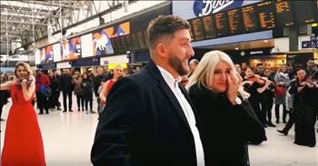 Sometimes even a flash mob is not what it seems. At a busy train station, Adam orchestrates a Flash Mob surprise orchestra proposal for his girlfriend, Mlayne. Thinking she was going through Waterloo Station to meet family and friends for her birthday, Mlayne was in for quite the surprise!

As the video opens, a woman in stunning red dress is standing in the middle of the bustling station.  Looking at her watch, it’s clear that she is also holding a conductor’s baton. A solo violinist is filmed walking up to the woman with his violin and case in hand, he hands the case off to a passerby (hint: It’s Adam!).  As the musician begins playing the familiar “Hallelujah Chorus” from Handel’s “Messiah” other musicians begin appearing around Adam and Mlayne until they were surrounded by a stunning orchestra!

Once everyone was in place, the song seamlessly morphed into the contemporary song “Just the Way You Are” by artist Bruno Mars.

“When I see your face
There's not a thing that I would change
'Cause you're amazing
Just the way you are
And when you smile
The whole world stops and stares for a while
'Cause, girl, you're amazing
Just the way you are”

As the song concludes, Adam opens the violin case he was holding to reveal the surprise message inside: “Will You Marry Me” with a red rose attached. Mlayne, already in tears from the flash mob, said YES and the joyous occasion was marked with whistles and cheers from the surrounding crowd. Congratulations to the happy couple and may God bless their upcoming nuptials!