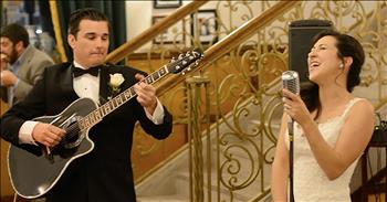 These wedding guests were in for a treat when this bride and groom sing the classic Etta James song, ‘At Last.’ 

This song was originally written in 1941 for a musical, but it wasn’t until 1960 that it became the iconic tune it is today. Etta James recorded her own arrangement and the song went straight to number one. 

This song continues to be regularly played and covered by other artists even decades after it’s release. And whenever you hear those famous lyrics, it truly transports you back to another time and place.

“At last my love has come along
My lonely days are over and life is like a song, oh yeah
At last the skies above are blue
My heart was wrapped up clover the night I looked at you”

Today, this bride and groom are celebrating their wedding day in a very special way. They wanted to profess their love for one another through song at the reception. That’s when they stood up together and started to sing ‘At Last.’ 

The groom plays the guitar while his beautiful bride provides the vocals. It’s obvious that these two are very much in love and both have a talent for performing. This new bride belts out the lyrics without missing a single note. 

This isn’t an easy song to perform, but these two definitely nailed it. I’m sure this was such a treat for the wedding guests to hear on this celebratory day. We wish this husband and wife a lifetime of happiness and many more duets together. 