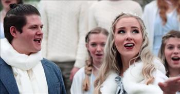 In this epic cover, a husband and wife duo sing a mashup of ‘Let It Go’ and ‘Into The Unknown’ with the Rise Up Children’s Choir.
 
This entertaining video shows the choir of kids dancing around in matching costumes, with many of the girls wearing braids in their hair like Elsa from Frozen. Their talented voices are also highlighted in this creative mashup that is so fun to watch. There are even some aerial shots in the music video that show the children dancing on a fountain from a bird’s eye view.
 
The children and adults looked like they had an equally fun time making this video as they can be seen having a great time running around a park called Evermore.
 
Located in Pleasant Grove, Utah, Evermore is an “experience <a href="https://www.youtube.com/watch?v=gvxdu_J-p4s">park</a> where guests of all ages can escape to a new realm. The park is built like a European Village with a twist of fantasy with its own buildings, citizens, and epic story.”
 
The husband and wife singing in the video are Scott and Ryceejo Shattuck. They have their own YouTube <a href="https://www.youtube.com/channel/UCrzTuQ42jo47RtVvePPYXCg/about">page</a> and make “fun, family-friendly music that people of all ages enjoy.” The two love to focus on a cappella covers, especially mashups of Disney songs. Scott and Ryceejo record, edit, and produce all of their own music. Scott also sang a cappella in college and has worked with many artists, including Ben Bram from Pentatonix. It is clear that they are both very talented singers, and listening to Scott hit those incredibly high notes in this video will leave you very impressed!
 
As for the Rise Up Children’s Choir, it was founded in 2019 by Amy Oakeson and Suzy Oliveira. The group is “a brand-new, Utah-based children's <a href="https://www.youtube.com/channel/UCOa7boSHFG5dzpXhH27ikfQ/about">choir</a>
that is comprised of children ages 6 to 18 with advanced musical training.” Scott and Ryceejo Shattuck are the musical directors of the children’s choir.
