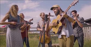 If you are looking for a video of peaceful scenery and natural talent, look no further. In this clip, the Riverside Bluegrass Band performs “Ole Montana” in a pasture. 

The five performers are standing together in front of hay bales and the beautiful mountains on a sunny day. It feels as if you are right there with them. The male and female sing in harmony and blend so perfectly. The camera gives moments highlighting each instrument. We hear and see guitar, violin, mandolin, bass, and a fiddle. 

Riverside Bluegrass Band was started by a group of friends from California and Texas. These incredible young people inspire us to slow down and enjoy the nature around us and all of the beauty that God has created. Their music and setting welcome us into the awe and wonder of the creation made by the Lord. The state of Montana is absolutely breathtaking and this music video will get anyone excited about the gift of nature around them.

The Bible tells us clearly that the work of the Lord through creation reveals the invisible qualities of His power and holiness. We clearly see the working of the Creator when we look at the immaculate mountains, waterfalls, oceans, skies, plants, animals, and everything around us pointing to the Higher One. 

When was the last time you appreciated the setting God has provided around where you live? It may not be Montana, but God’s handiwork is everywhere, we just need to slow down and take time to notice Him.

“For since the creation of the world God’s invisible qualities—his eternal power and divine nature—have been clearly seen, being understood from what has been made, so that people are without excuse.” <a href="https://www.godtube.com/bible/romans/1-20">Romans 1:20</a>
