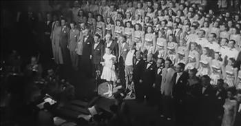 <p>If you have ever wanted to see a rare clip of a young Julie Andrews, this is a special moment. In this video, 13-year-old Julie Andrews sings for King George VI in a classic clip.</p>

<p>In front of a grand choir, a precious young girl in a cute dress comes out onto the stage. It is little Julie Andrews. She runs over to the microphone and begins by singing the British national anthem. King George VI and Queen Elizabeth I are at the 1948 Royal Command Performance at London&#39;s Palladium.&nbsp;&nbsp;</p>

<p>Her young voice is very mature and confident for such a young age. She stands with poise and grace as she performs.&nbsp;</p>

<p>&nbsp;</p>

<p>Then, suddenly the entire choir and instruments join for a powerful performance. There is such patriotism and high energy from all of the choir and orchestra. You can hear a high note hit at the end of the song that might be Julie herself. The entire audience applauds and cheers after a wonderful performance.&nbsp;</p>

<p>The camera zooms in on Julie in her adorable white dress, standing in front of the choir with a huge smile on her face. She is clapping with immense enthusiasm and happiness. You can tell that this was a huge honor and privilege for her in life. She had the opportunity to sing for royalty at such a young age.&nbsp;</p>

<p>We can feel this type of honor today. The King of all has invited us to His table. He has made us co-heirs with Christ. He has called us His bride. He is so worthy of honor and our song, yet He welcomes us and knows us by name. We serve a personal King.</p>

<p><em>That he worked in Christ when he raised him from the dead and seated him at his right hand in the heavenly places, far above all rule and authority and power and dominion, and above every name that is named, not only in this age but also in the one to come. <a href="https://www.godtube.com/bible/Ephesians/1-20">Ephesians 1:20-21</a></em></p>
