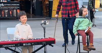 <p>Little Nicholas Protsenko delivers a sweet and adorable rendition of &lsquo;Moon River&rsquo; while likely having little or no understanding of the song&rsquo;s rich history. However, many of the adoring adults watching and listening to the song know the song well, the movie it&rsquo;s from, and the most famous versions of it. That knowledge only adds to the pleasure of hearing it sung so wonderfully by this talented 3-year-old tike!</p>

<p>Nicholas is accompanied by his brother, 6-year-old Leo, and his 16-year-old sister, Karolina, is just to Nicholas&rsquo;s left. She holds her violin and is there to assist her younger brothers as needed. The three are regular performers in the streets of Santa Monica, California, but they are known much more widely. Karolina&rsquo;s YouTube channel has 8.5 million subscribers, and Leo&rsquo;s has nearly 44,000! No doubt, Nicholas will follow in their paths. All the children have inherited their musician parents&rsquo; talent!</p>

<p>Nicholas gives an excited little shiver at the first note, and Leo is all smiles as he plays the song&rsquo;s piano introduction. The two are dressed in sweatshirts&mdash;appropriate for Southern California&rsquo;s December weather. Nicholas&rsquo;s feet dangle above the street from where he sits perched on a stool, and his hair is tied up so it doesn&rsquo;t hang in his eyes. Leo&rsquo;s legs are just long enough to navigate his keyboard&rsquo;s pedals.&nbsp;&nbsp;</p>

<p>Before too long, Nicholas has been given a tambourine to hold in his restless little boy paws. As far as Leo, he seems so at ease and skilled. He watches the crowd as much as they watch him and his little brother. The two are amazing!</p>

<p>&lsquo;<a href="https://en.wikipedia.org/wiki/Moon_River">Moon River</a>&rsquo; was composed by Henry Mancini, and the words were written by Johnny Mercer. Written for the movie <em>Breakfast at Tiffany&rsquo;s</em> and performed by the movie&rsquo;s lead Audrey Hepburn, the song won the 1961 Academy Award for Best Original Song. Images from Johnny Mercer&rsquo;s Savannah, Georgia childhood are set to a lovely, romantic melody. &lsquo;Moon River&rsquo; was later covered by Frank Sinatra, Louis Armstrong, Judy Garland, Amy Winehouse, Michael Bubl&eacute;, and others. Andy Williams named his Branson, MO theater after the iconic song, which became a huge hit for him. &nbsp;&nbsp;&nbsp;&nbsp;</p>

<p>While Nicholas and Leo may not know all that song history, they sure know how to make those listening live and later smile. A beautiful little boy singing a beautiful song&mdash;it doesn&rsquo;t get much better! The hearty applause from the admiring crowd proves that!</p>

<p><em>&ldquo;The unfolding of your words gives light; it gives understanding to the simple.&rdquo; <strong><a href="https://www.godtube.com/bible/psalms/119-130">Psalms 119:130</a></strong></em></p>

