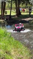 A toddler drives through a flowing stream in a child's version of an offroad vehicle. Credit: Gerson Jiménez