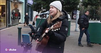 <p>This dazzling rendition of Sixpence None the Richer&rsquo;s &ldquo;Kiss Me&rdquo; will have you daydreaming. The singer&rsquo;s voice is ever so sweet&mdash;a perfect match for this dreamy song. Play the video to step into the experience.</p>

<p>The video's ambience is cold and grey as busker Vicka stands on a Dublin sidewalk. However, her voice is an absolute ray of delicious warmth that contrasts deeply with the setting. The young artist surely brightened the day for anyone who walked by or stopped to hear her sing.&nbsp;</p>

<p>Her guitar playing is so soothing and mellow, which goes along perfectly with her sweet voice. She&rsquo;s chosen a wonderful song to suit her skill set. The 90s song offers an irresistible happy vibe.&nbsp;</p>

<p>The song was written and released by Sixpence None the Richer in 1997. Since then, the song has <a href="https://www.savagecontent.com/post/6-songs-that-gained-more-popularity-from-movies">seen</a> the limelight in several shows and movies, including &ldquo;She&rsquo;s All That&rdquo; and &ldquo;Dawson&rsquo;s Creek.&rdquo; Some of the dreamy <a href="https://genius.com/Sixpence-none-the-richer-kiss-me-lyrics">lyrics</a> are:</p>

<p>Kiss me out of the bearded barley<br />
Nightly beside the green, green grass<br />
Swing, swing, swing the spinning step<br />
You wear those shoes and I will wear that dress</p>

<p>All of the lyrics sound like a fantasized, hazy love story&mdash;in a good way. Its swoony sound is still popular today, like it was in the late 90s.&nbsp;</p>

<p>One of Sixpence None the Richer&rsquo;s members, Leigh Nash, <a href="https://people.com/sixpence-none-the-richer-kiss-me-sabrina-carpenter-exclusive-8730983">said</a> she loves the song because &ldquo;it makes people so happy. That's a completely different generation, obviously, so it's a connector. The song is obviously connected with a ton of people. So, who would be mad about that?&rdquo;</p>

<p>A few of the band&rsquo;s other hits are &ldquo;There She Goes&rdquo; and &ldquo;Don&rsquo;t Dream It&rsquo;s Over.&rdquo;&nbsp;</p>

<p>All in all, Vicka&rsquo;s cover of &ldquo;Kiss Me&rdquo; is certainly a bright spot of nostalgia on a cloudy day. Wouldn&rsquo;t you agree?</p>
