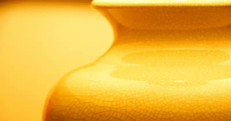 extreme closeup of the neck of a golden-colored clay or porcelain vase