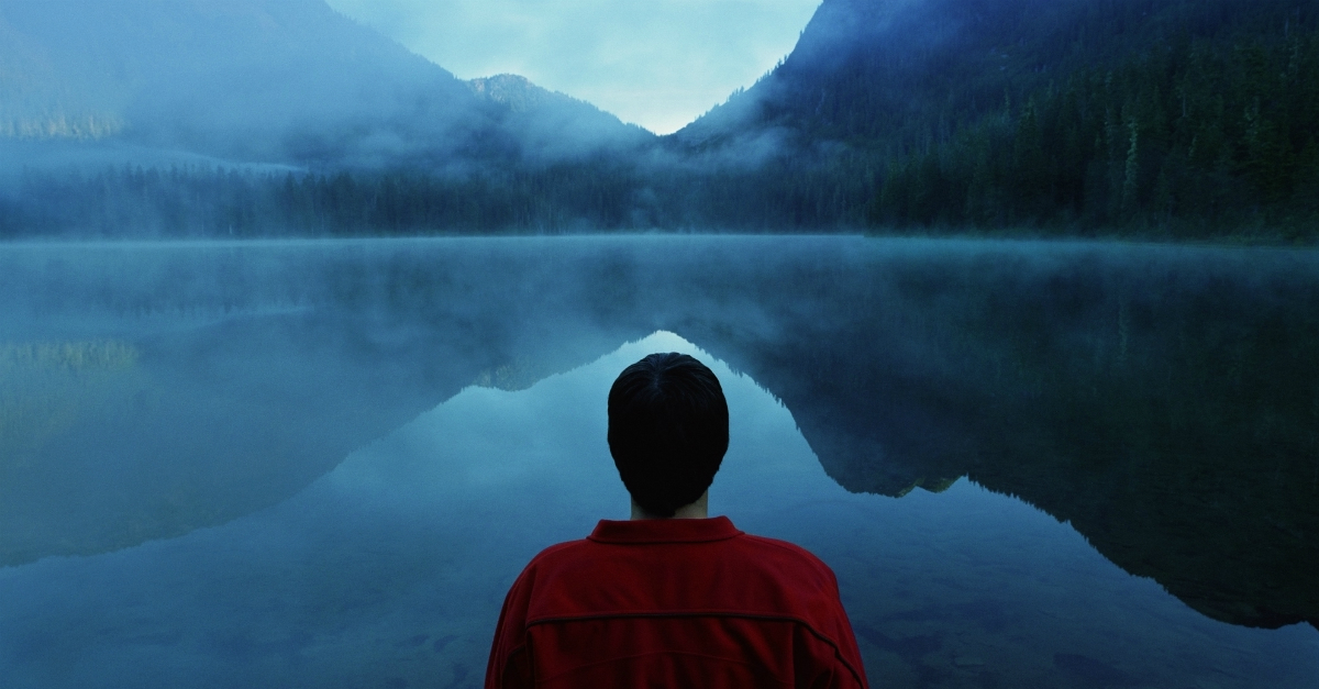 man looking at blue lake, pray without ceasing