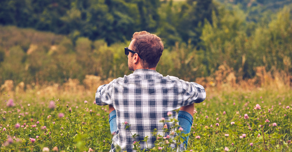 Man sitting and relaxing in a field of wildflowers