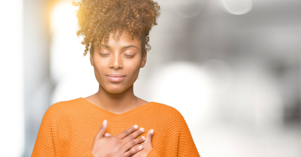 woman with eyes closed hands over heart The Lord Is Near to the Brokenhearted