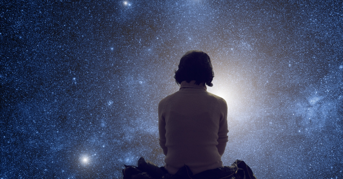 woman looking at the starry sky in wonder of God