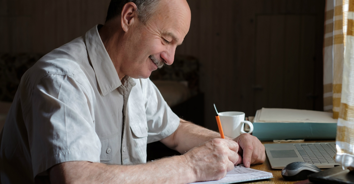 Senior man writing in a notebook