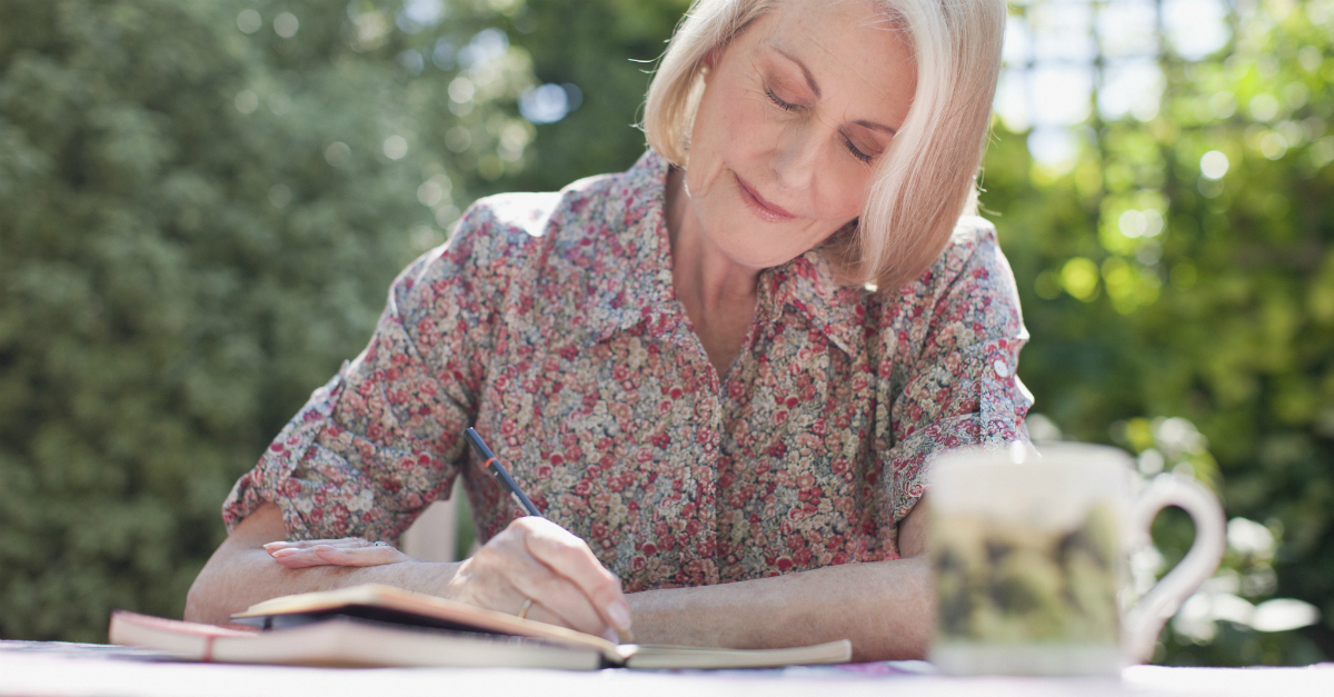 senior mature woman writing in journal