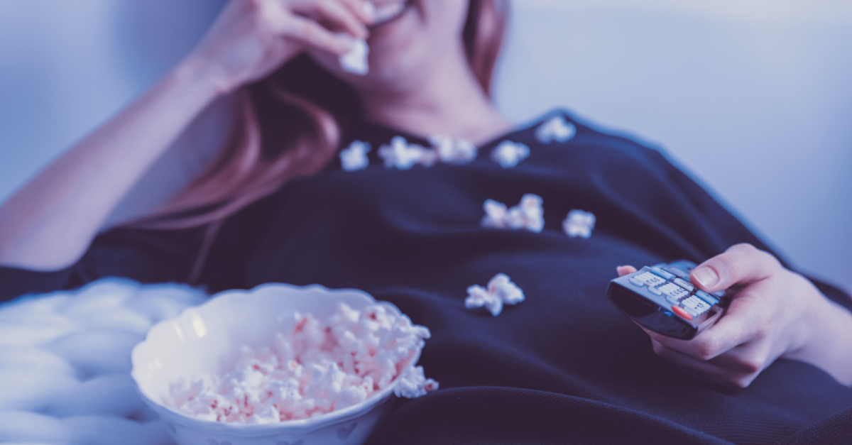 Woman eating popcorn and watching TV