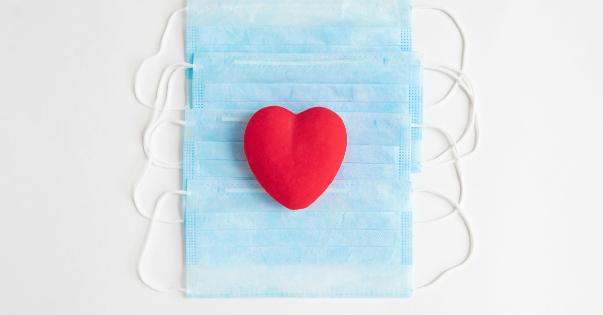 puffy red heart on a stack of face masks for COVID-19