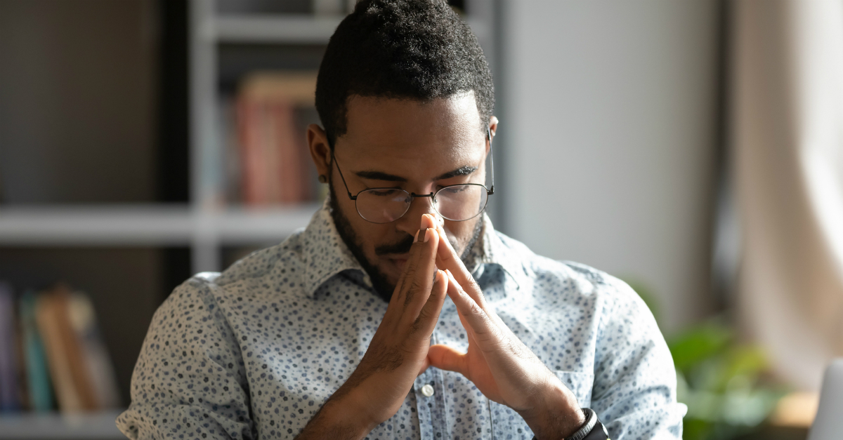man in home office praying for a hedge of protection