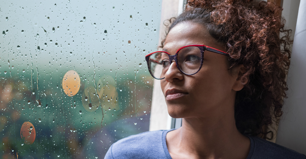woman looking sad and thoughtful out rainy window, whose fault is it you're angry 