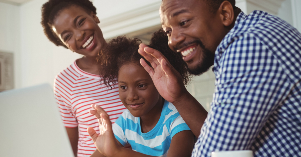 family waving to laptop connecting virtually due to COVID-19