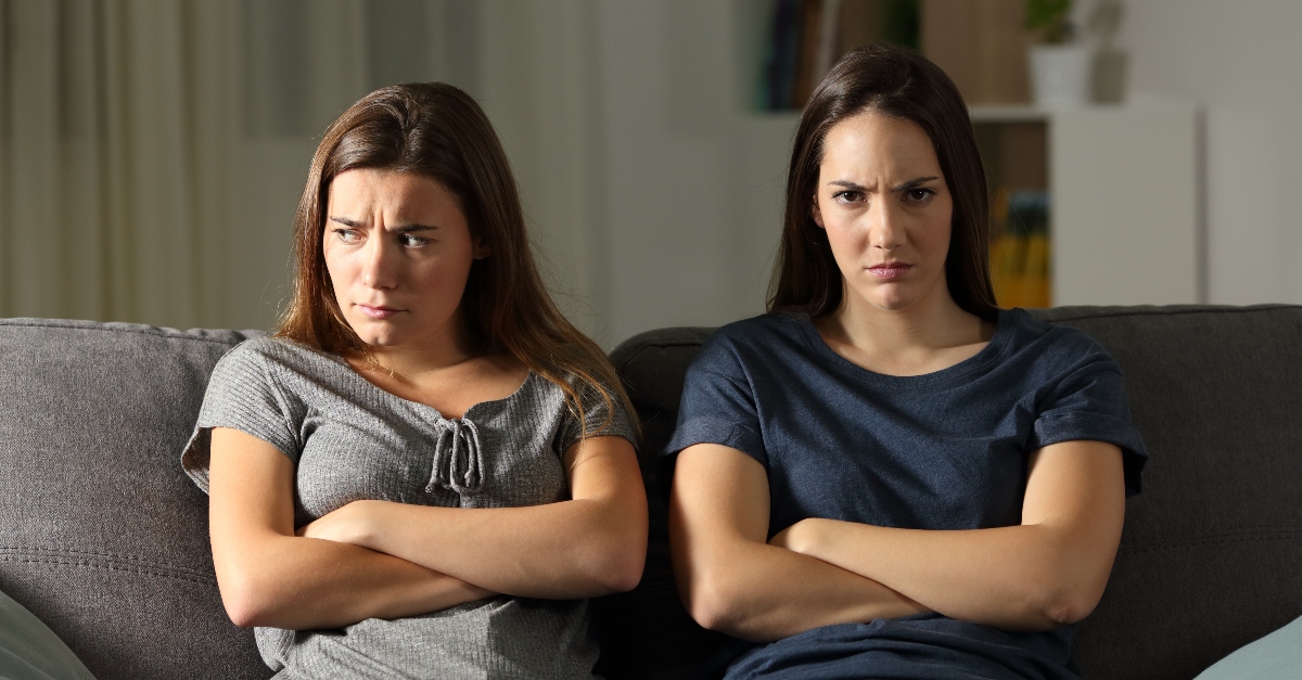 two women sitting on couch with crossed arms looking upset and angry, how to forgive when you dont feel forgiving