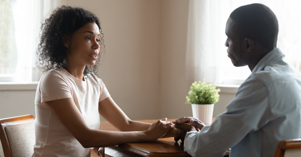 Woman and man couple sitting and talking with serious expressions, how to respond to spouse's question