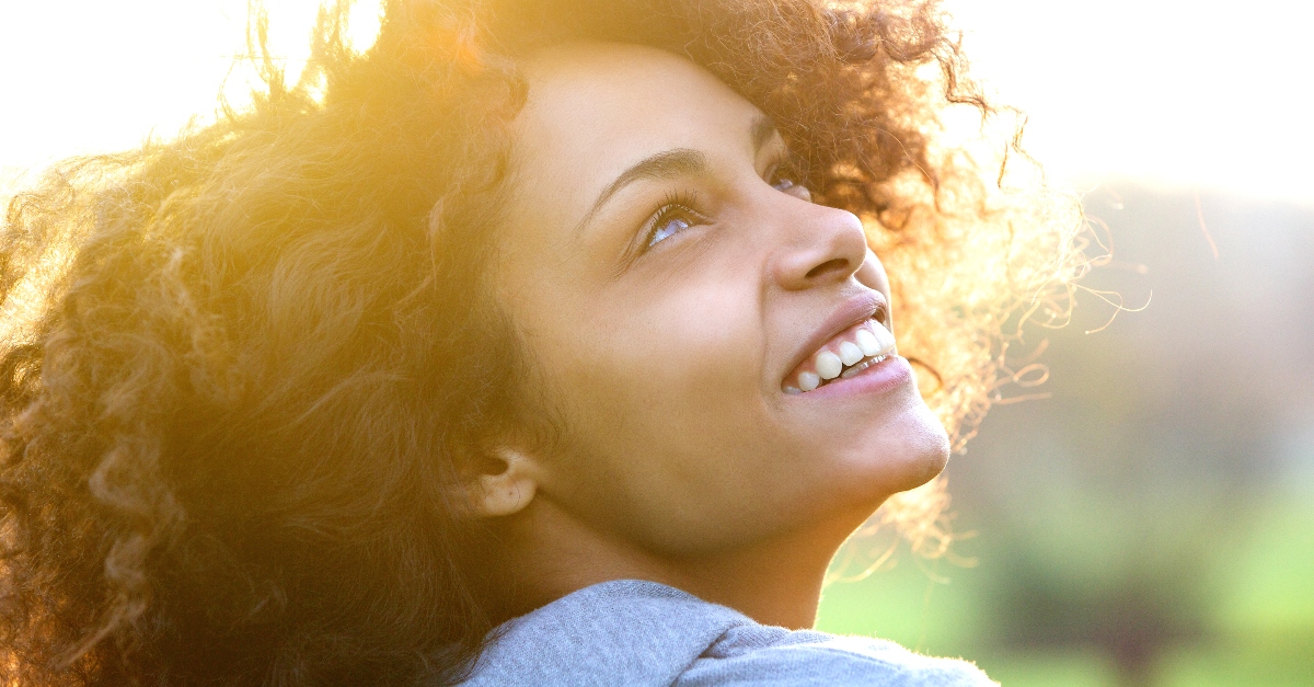 close up of woman looking up joyfully smiling, apple of my eye