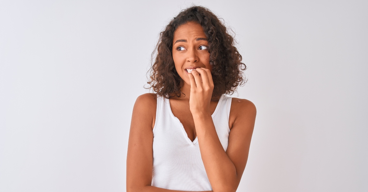 Nervous woman biting her nails, reasons you're feeling stuck and how to break free