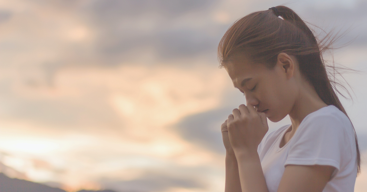 woman praying against sunset, "blessed are the meek"