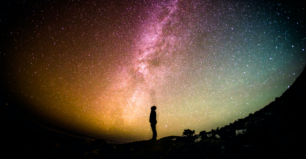 man looking at the stars outside