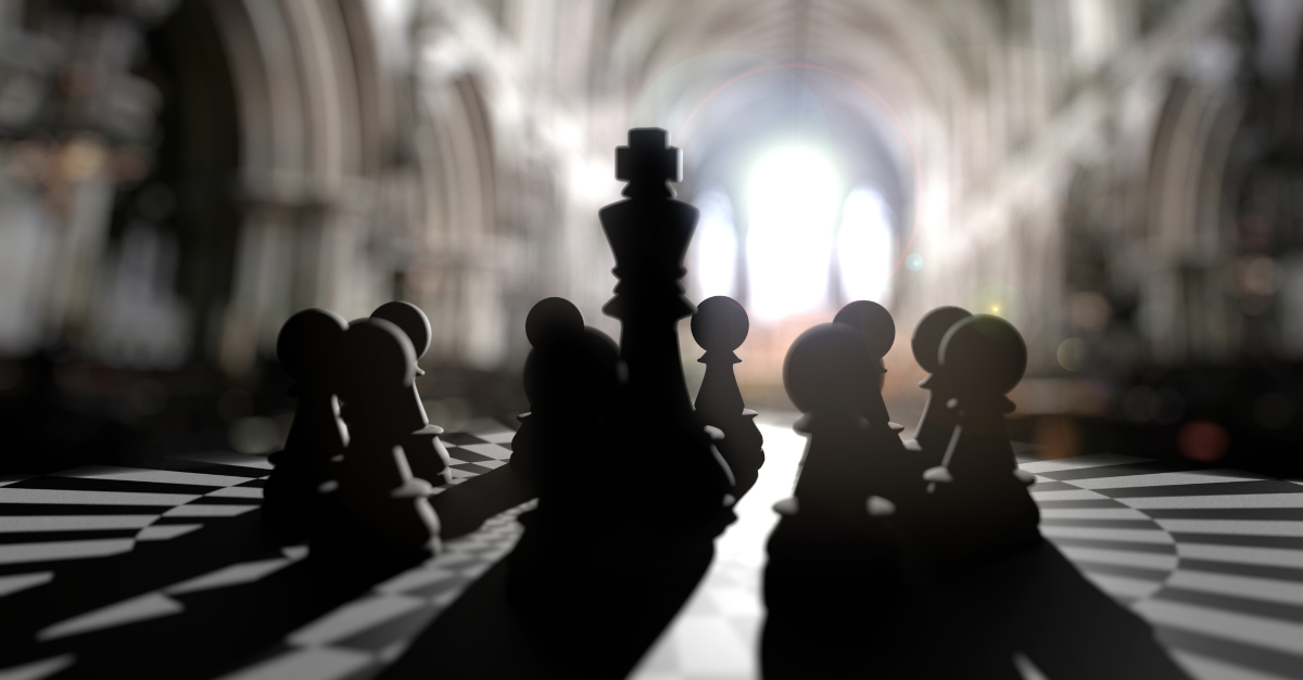 King chess piece in center of pawns leadership arrogance