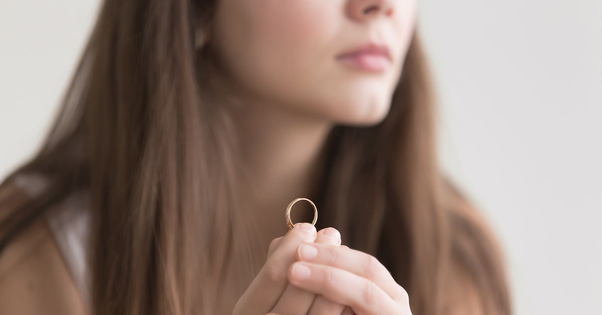 woman holding wedding ring in her hand