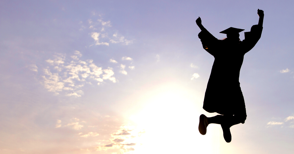 Silhouette of a college graduate jumping for joy