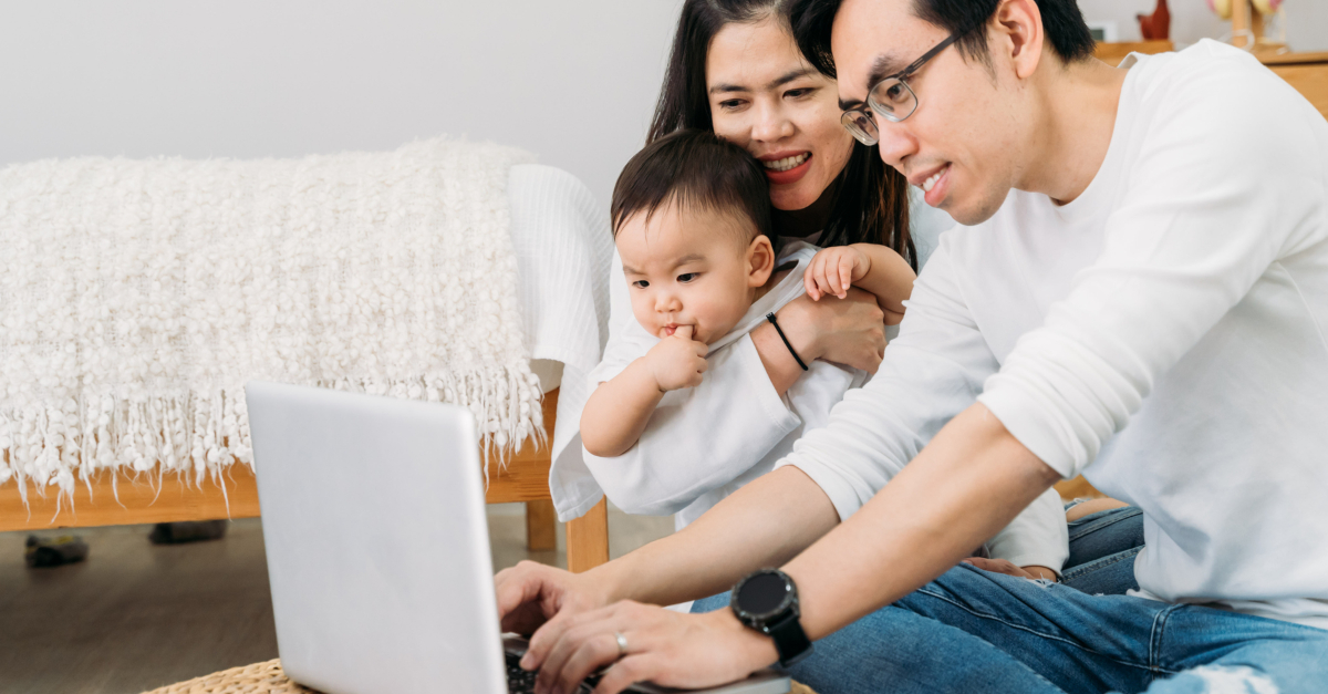 asian family with baby watching church online on laptop