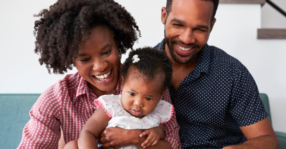 couple with baby watching church online on laptop