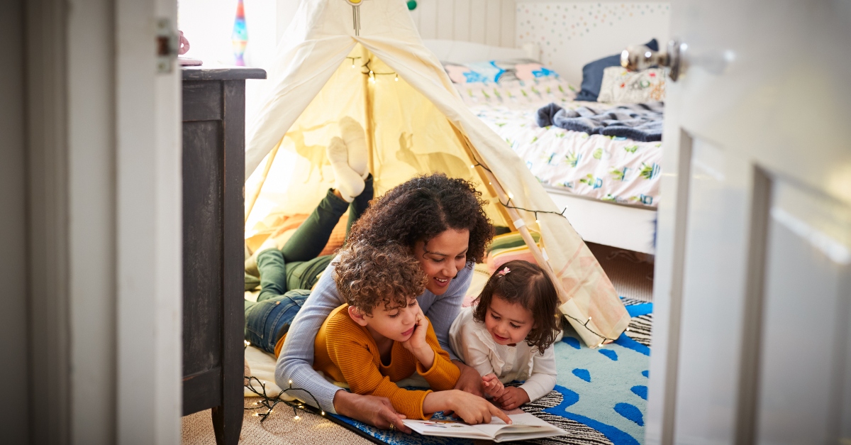 mom reading with her kids in a tent in bedroom