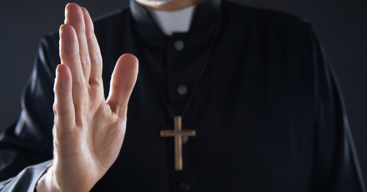 Catholic priest raising hand in blessing